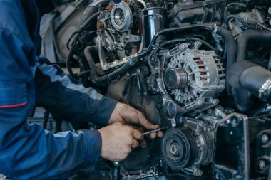 Otomatik tamirci bir motoru tamir eder. Zamanlama zinciri değiştiriliyor