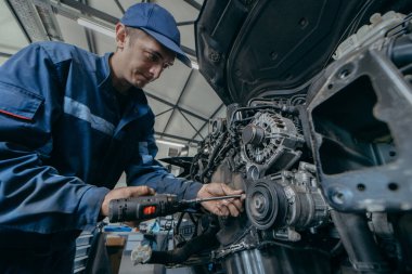 Otomatik tamirci bir motoru tamir eder. Zamanlama zinciri değiştiriliyor