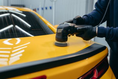 Atölyede sarı spor arabanın parlatılması süreci