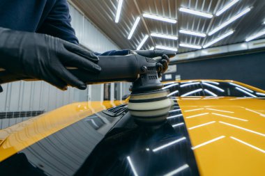 Atölyede sarı spor arabanın parlatılması süreci