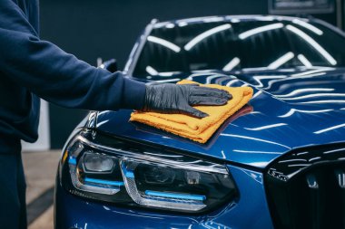 Cilaladıktan sonra mavi araba gövdesini lifle silmek