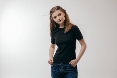 Stüdyoda siyah tişört giyen şık bir kız.