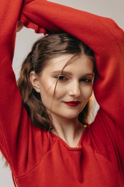 Stüdyoda beyaz arka planda kırmızı elbiseli genç kız.