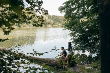 Yetişkin çift yazın göl kenarında doğada dinleniyor.