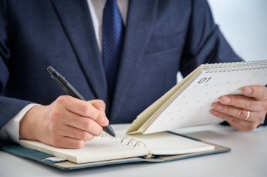 Bir iş adamının elleri günlük tutarken ya da fikirlerini yazarken.