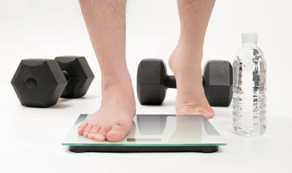 Asian Middle Aged Man Feet Measuring Weight lizenzfreie Stockfotos