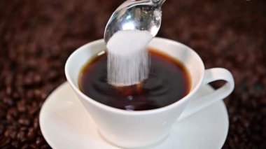 Putting white sugar in a coffee cup
