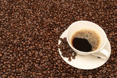 Cup of coffee on brown coffee beans