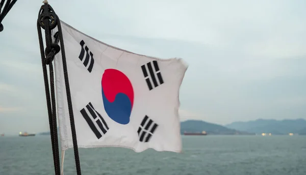 The Korean flag of the cruise ship swaying in the wind.