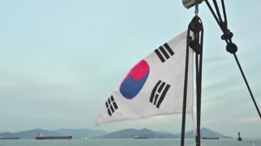 The Korean flag of the cruise ship swaying in the wind.