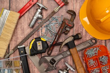 Ahşap bir tahtaya, ev onarımı için gerekli çeşitli aletler düzensiz olarak yerleştirilir..