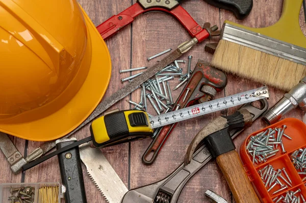 Ahşap bir tahtaya, ev onarımı için gerekli çeşitli aletler düzensiz olarak yerleştirilir..