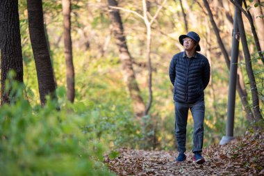 Düşen yapraklı bir yolda yalınayak yürüyen bir adam. Sağlıklı yaşam tarzı kavramı