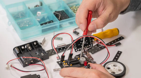 Close-up of hands assembling robotics educational toy. STEM education concept