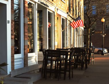 Skaneateles, New York, ABD. 4 Kasım 2022. Skaneateles, New York 'ta bir barın önünde güzel bir sonbahar sabahı sandalyeler ve masalar.