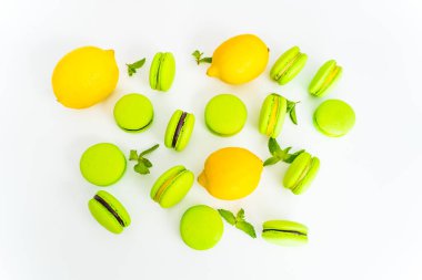 Green macaron with chocolate filling. Top view, layout with lemon and mint, confectioner
