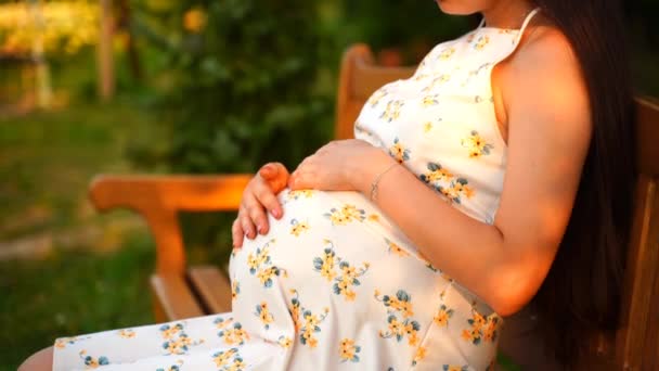Hamile Bir Kız Parkta Beyaz Elbiseli Bir Bankta Oturuyor Karnını — Stok video