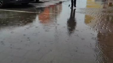 Bir çocuk yağmurlu havada su birikintilerinde yürür ve su birikintilerinde ev yapımı bir tekne çeker. Çocukluk kavramı, hava durumu, yalnızlık, hiç arkadaş yok. Yüksek kalite 4k görüntü