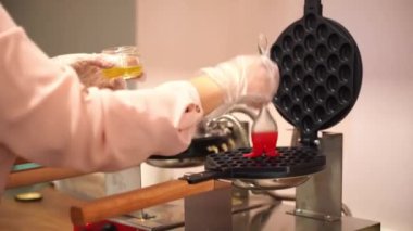 Fırıncı waffle ızgarasını yağlar ve dökmeden önce kapsama alanını dengeler. Mutfakta, bir kafede, bir restoranda çalışıyorum. Yüksek kaliteli FullHD görüntüler