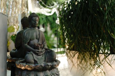 Ruhsal uyanış. Buda heykeli ve kısa meditasyon. Zen ruhani ritüeli beyaz Buda yüzü üzerinde meditasyon, yeşil çiçekli kahverengi mum.