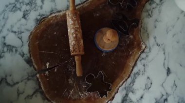 Noel mutfağında ve Noel süslemelerinde masanın üzerinde merdane ve kurabiye keskisi var. Noel kurabiyesi yapıyorum. Yukarıdan bak, mutfak duvarına geç, Noel ağacı