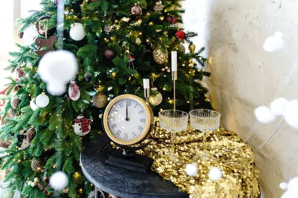 Yılbaşı afişi, noel ağacının yanında bir sehpanın yanında yuvarlak saat ve gözlüklerle. Yüksek kalite fotoğraf
