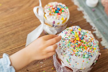 Yukarıdan bak. Kızlar, çok renkli şekerleme parçacıklarıyla süslenmiş Paskalya 'ya uzanıyor. Yüksek kalite fotoğraf