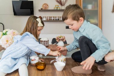 Bir erkek ve bir kız mutfakta paskalya pastası süslüyor. Paskalya hazırlığı. Yüksek kalite fotoğraf