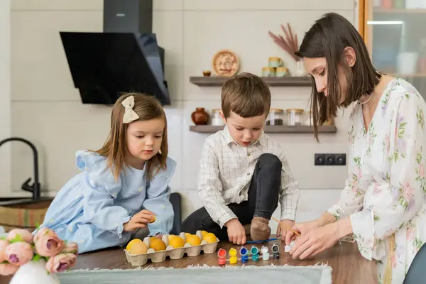 Bir aile Paskalya için mutfakta paskalya yumurtası boyayarak hazırlanıyor. Yüksek kalite fotoğraf