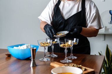 Mutfakta bir aşçı, fincanda dondurma hazırlıyor. Tatlı. Yüksek kalite fotoğraf