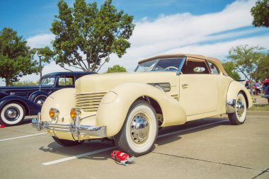 WESTLAKE, TEXAS - 15 Ekim 2022: Açık sarı 1937 Cord 812 Phaeton klasik araba ön görünümü. 
