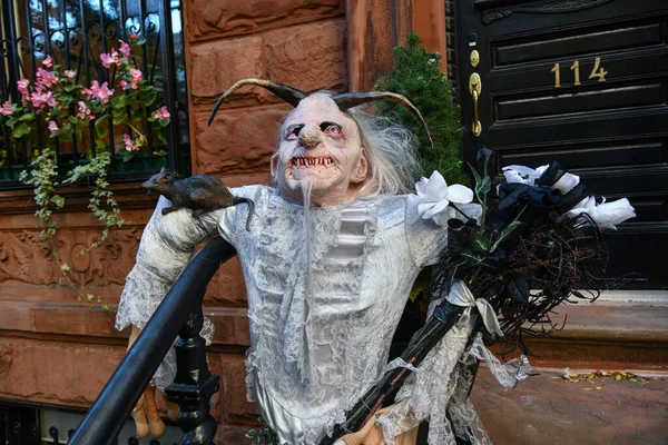 Scary character on the stairs of the house as outdoor Halloween decoration.