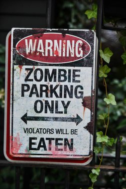 Warning zombie sign as outdoor Halloween decoration. clipart