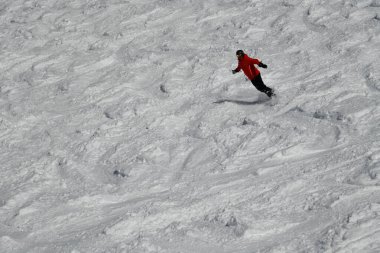 Snowboarder running down the slope in Vail Mountain Resort. Winter sport and recreation, leisure outdoor activities.