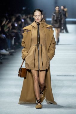 MİLAN, İTALYA - 24 Şubat 2023 'te Milano Moda Haftası Kadın Giyim / Kış 2023 / 2024' te İtalya 'nın Milano kentinde Tods defilesinde bir model podyumda yürüyor..