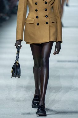 MİLAN, İTALYA - 24 Şubat 2023 'te Milano Moda Haftası Kadın Giyim / Kış 2023 / 2024' te İtalya 'nın Milano kentinde Tods defilesinde bir model podyumda yürüyor..