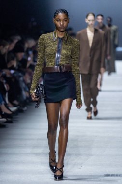 MİLAN, İTALYA - 24 Şubat 2023 'te Milano Moda Haftası Kadın Giyim / Kış 2023 / 2024' te İtalya 'nın Milano kentinde Tods defilesinde bir model podyumda yürüyor..