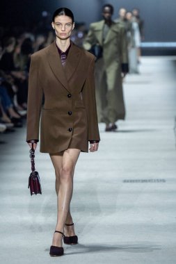 MİLAN, İTALYA - 24 Şubat 2023 'te Milano Moda Haftası Kadın Giyim / Kış 2023 / 2024' te İtalya 'nın Milano kentinde Tods defilesinde bir model podyumda yürüyor..