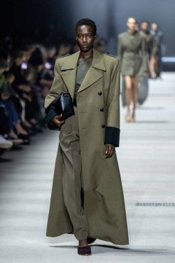 MİLAN, İTALYA - 24 Şubat 2023 'te Milano Moda Haftası Kadın Giyim / Kış 2023 / 2024' te İtalya 'nın Milano kentinde Tods defilesinde bir model podyumda yürüyor..