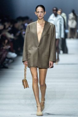 MİLAN, İTALYA - 24 Şubat 2023 'te Milano Moda Haftası Kadın Giyim / Kış 2023 / 2024' te İtalya 'nın Milano kentinde Tods defilesinde bir model podyumda yürüyor..