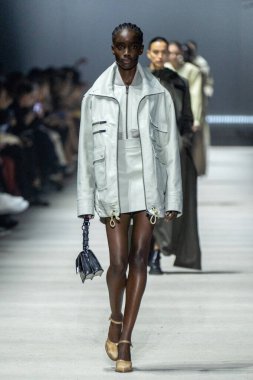 MİLAN, İTALYA - 24 Şubat 2023 'te Milano Moda Haftası Kadın Giyim / Kış 2023 / 2024' te İtalya 'nın Milano kentinde Tods defilesinde bir model podyumda yürüyor..