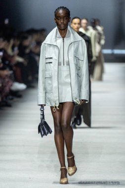 MİLAN, İTALYA - 24 Şubat 2023 'te Milano Moda Haftası Kadın Giyim / Kış 2023 / 2024' te İtalya 'nın Milano kentinde Tods defilesinde bir model podyumda yürüyor..