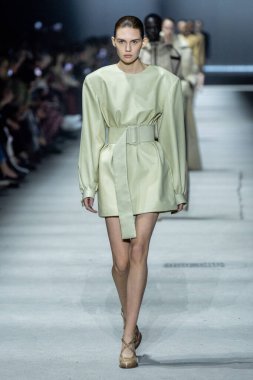 MİLAN, İTALYA - 24 Şubat 2023 'te Milano Moda Haftası Kadın Giyim / Kış 2023 / 2024' te İtalya 'nın Milano kentinde Tods defilesinde bir model podyumda yürüyor..