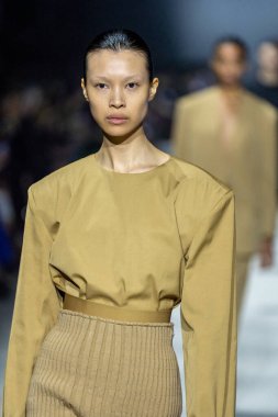 MİLAN, İTALYA - 24 Şubat 2023 'te Milano Moda Haftası Kadın Giyim / Kış 2023 / 2024' te İtalya 'nın Milano kentinde Tods defilesinde bir model podyumda yürüyor..