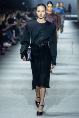 MİLAN, İTALYA - 24 Şubat 2023 'te Milano Moda Haftası Kadın Giyim / Kış 2023 / 2024' te İtalya 'nın Milano kentinde Tods defilesinde bir model podyumda yürüyor..