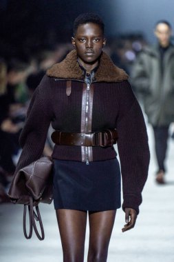 MİLAN, İTALYA - 24 Şubat 2023 'te Milano Moda Haftası Kadın Giyim / Kış 2023 / 2024' te İtalya 'nın Milano kentinde Tods defilesinde bir model podyumda yürüyor..