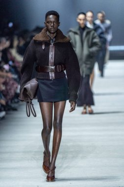 MİLAN, İTALYA - 24 Şubat 2023 'te Milano Moda Haftası Kadın Giyim / Kış 2023 / 2024' te İtalya 'nın Milano kentinde Tods defilesinde bir model podyumda yürüyor..