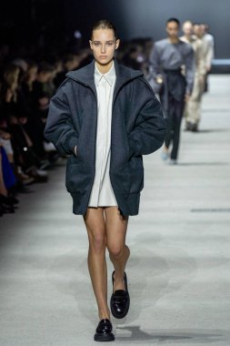 MİLAN, İTALYA - 24 Şubat 2023 'te Milano Moda Haftası Kadın Giyim / Kış 2023 / 2024' te İtalya 'nın Milano kentinde Tods defilesinde bir model podyumda yürüyor..