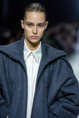 MİLAN, İTALYA - 24 Şubat 2023 'te Milano Moda Haftası Kadın Giyim / Kış 2023 / 2024' te İtalya 'nın Milano kentinde Tods defilesinde bir model podyumda yürüyor..