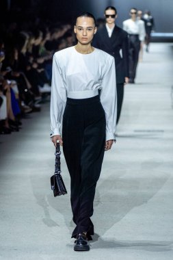 MİLAN, İTALYA - 24 Şubat 2023 'te Milano Moda Haftası Kadın Giyim / Kış 2023 / 2024' te İtalya 'nın Milano kentinde Tods defilesinde bir model podyumda yürüyor..